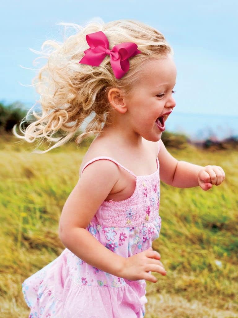 Wee Ones bow worn by child in lifestyle shot demonstrating secure, attractive wear