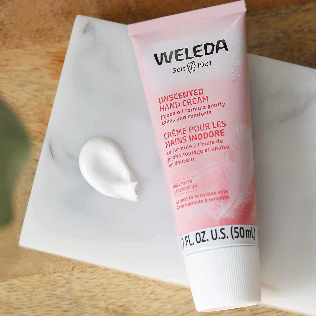 Person applying Weleda hand cream demonstrating fast absorption and non-greasy feel