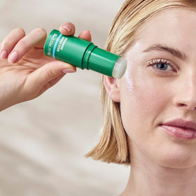 Weleda Skin Food serum stick held in hand for scale and travel-friendly convenience