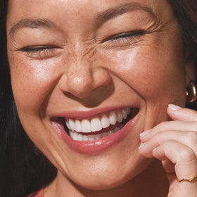 Well People lifestyle daytime glow on model demonstrating natural bronzed finish benefit