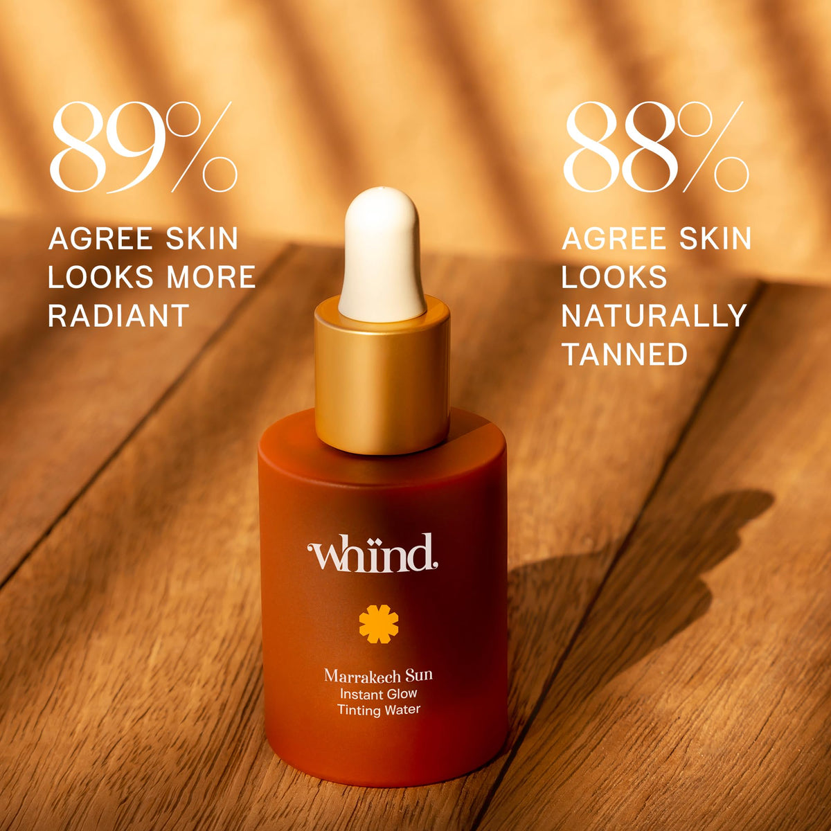 WHIND dropper pipette releasing clear tanning drops showing lightweight texture
