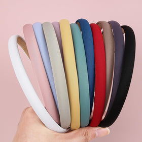 XIMA hand holding a single band to show scale and lightweight portability benefit