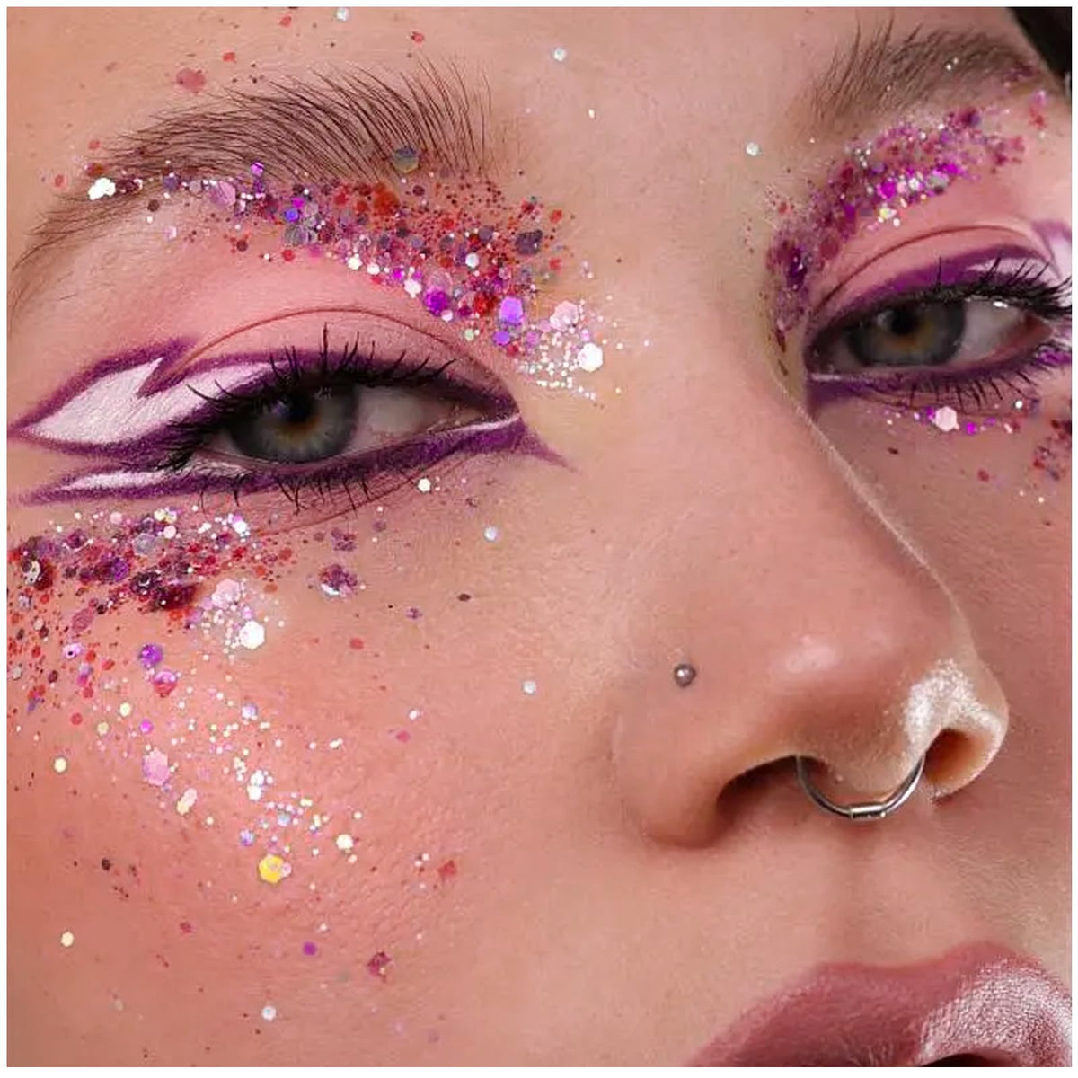YGQQOY festival lifestyle image of person dancing with glittered face and hair reflecting stage lights