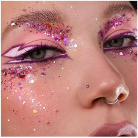 YGQQOY festival lifestyle image of person dancing with glittered face and hair reflecting stage lights