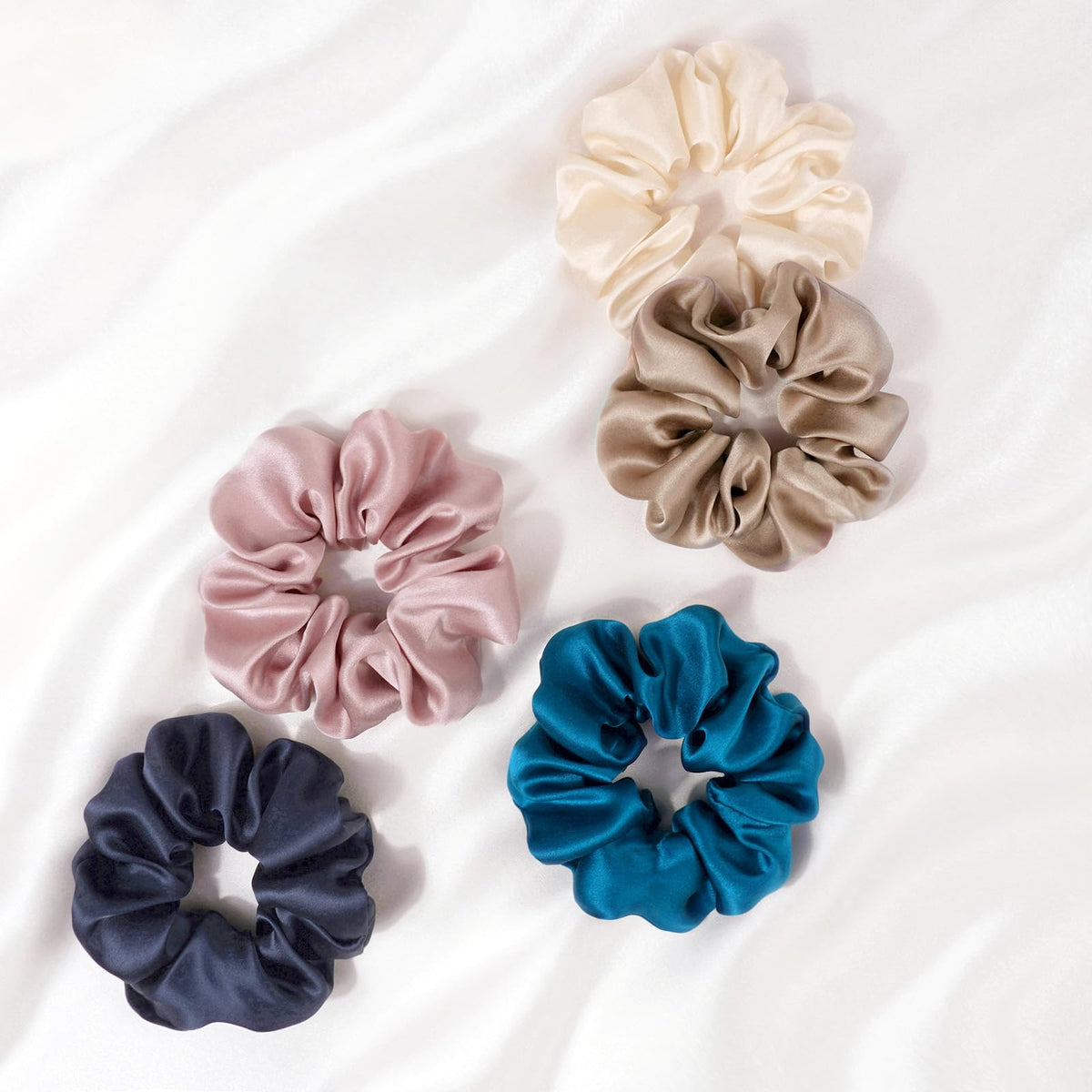 Zenssia scrunchie beside a hand for scale, shows comfortable size and stretch.