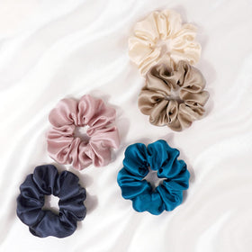 Zenssia scrunchie beside a hand for scale, shows comfortable size and stretch.